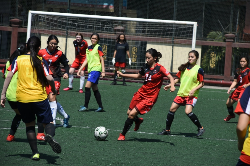 Amateur football players celebrating on a small-sided pitch.